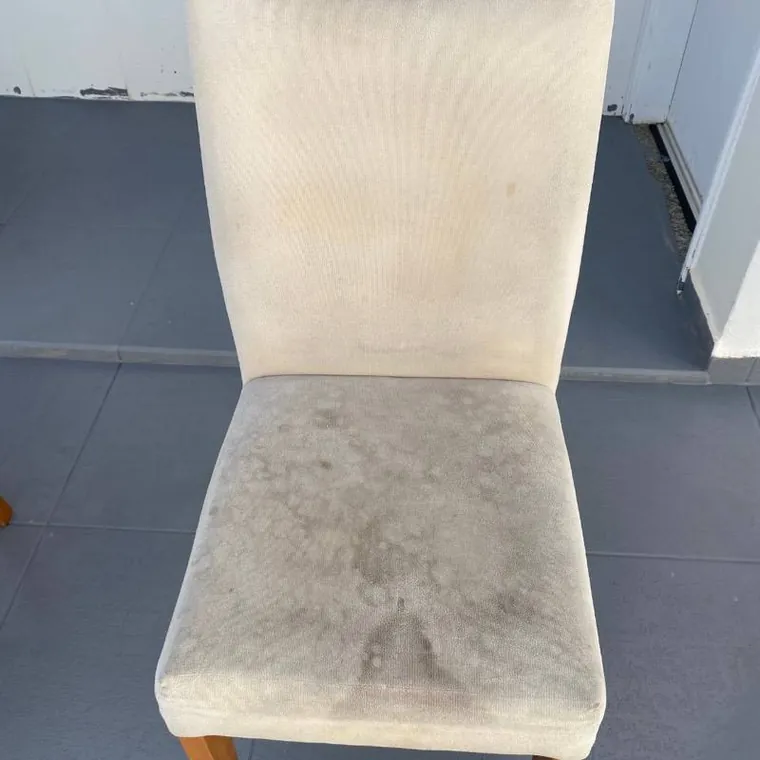 Cadeira de jantar estofada com o assento manchado, antes da limpeza